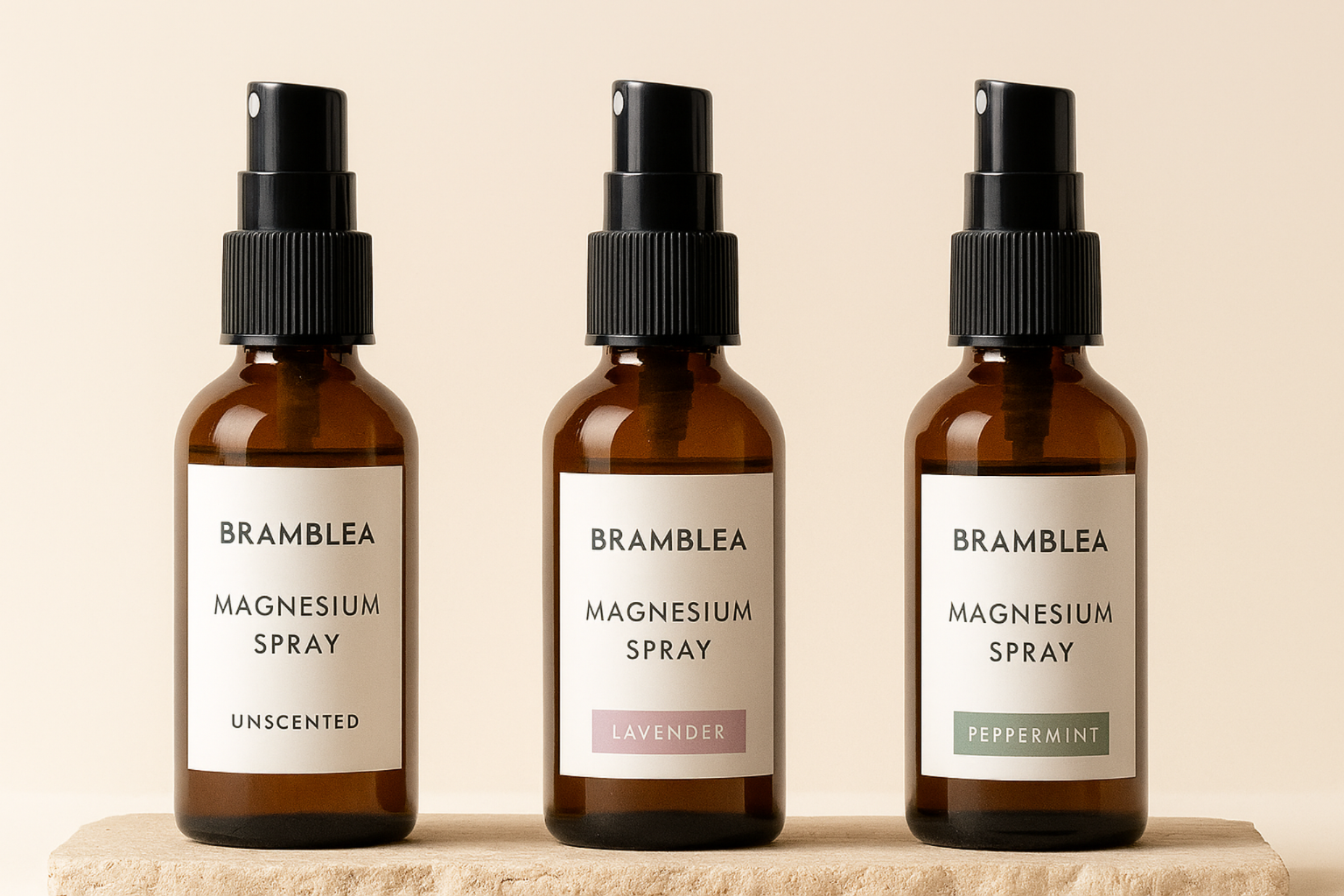 Three bottles of Bramblea magnesium spray on a beige background